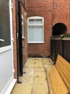 an alley with a brick wall and a window at Merrivale House in Birmingham