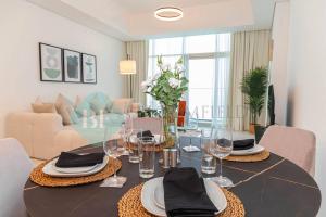 ein Esszimmer mit einem Tisch mit Tellern und Weingläsern in der Unterkunft Modern 1 Bedroom In Thalassa in Abu Dhabi