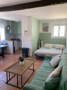 a living room with a green couch and a bed at Studio cosy avec clim 33m2 in Aimargues