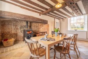 a dining room with a table and chairs and a fireplace at River House 6 in Kersey