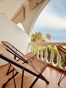 un par de sillas sentadas en un balcón en Afroditi Junior Suites, en Archangelos
