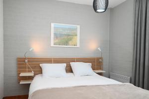 ein Schlafzimmer mit einem Bett mit zwei weißen Kissen in der Unterkunft The Green Studio, Lopinge 94 in Cadzand