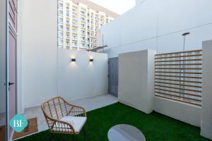 a small balcony with a chair and green grass at Premium 1 Br Duplex In Rukan in Dubai