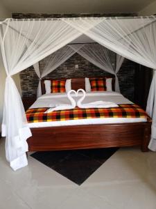 1 dormitorio con 1 cama con dosel en Queen's Way Resort, en Kisumu