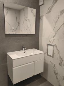 ein Badezimmer mit einem weißen Waschbecken und einem Spiegel in der Unterkunft The Courtyard 2Bdrm Apartment in Sofia + 22 Fotos