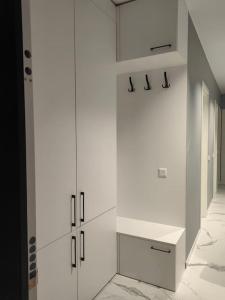 eine weiße Küche mit weißen Schränken in einem Raum in der Unterkunft The Courtyard 2Bdrm Apartment in Sofia