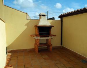 CardeñosaにあるCasa Rural El Caño Del Santoの家の脇の小さなレンガ造りの暖炉