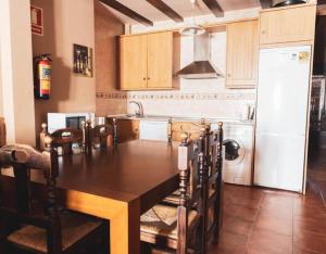Il comprend une cuisine équipée d'une table à manger et d'un réfrigérateur. dans l'établissement Casa Rural El Caño Del Santo, à Cardeñosa
