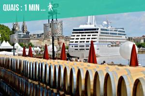 un bateau de croisière est amarré dans un port avec des parasols dans l'établissement FREE Parking - Self Checkin - WIFI - DUPLEX LA FUSTERIE - SUPERBORDEAUX, à Bordeaux