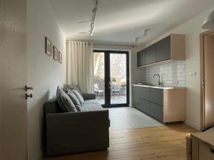 a living room with a couch and a kitchen at Apartament pod Wielką Sową in Pieszyce