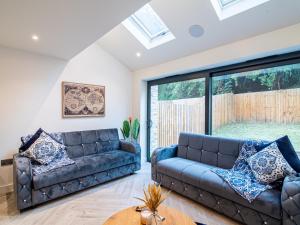 uma sala de estar com um sofá e uma mesa em Modern 4-Bed Townhouse, Conveniently Located Near Leeds City Centre - Perfect for Corporate Stays em Farnley