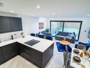uma cozinha e sala de estar com mesa e cadeiras em Modern 4-Bed Townhouse, Conveniently Located Near Leeds City Centre - Perfect for Corporate Stays em Farnley