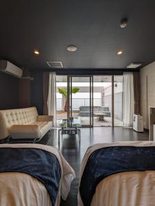 Duas camas num quarto com uma sala de estar em 瀬戸内リゾートホテル em Matsuyama
