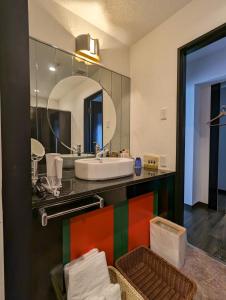 uma casa de banho com um lavatório e um espelho em 瀬戸内リゾートホテル em Matsuyama