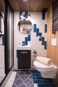 y baño con aseo, lavabo y espejo. en BaySide Apartments Marina Center en Gdansk