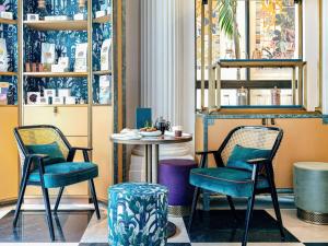 Sofitel Le Scribe Paris Opera في باريس: طاولة وكرسيين في غرفة مع طاولة
