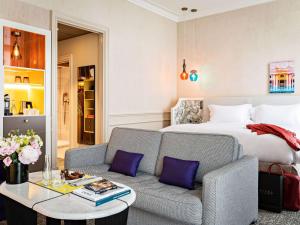 une chambre d'hôtel avec un lit et un canapé dans l'établissement Sofitel Le Scribe Paris Opera, à Paris