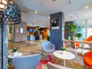 a lobby with chairs and tables in a building at Mercure Czestochowa Centrum in Częstochowa