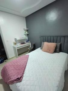 a bedroom with a white bed with a pink blanket on it at إقامة دشيرا الجديدة جهادية in Dcheira El Jihadia