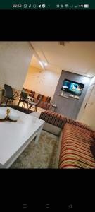 ein Wohnzimmer mit einem Sofa und einem TV in der Unterkunft إقامة دشيرا الجديدة جهادية in Dcheïra