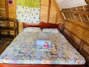 een kleine slaapkamer met een bed met bloemen erop bij Binucot Lodge in Romblon