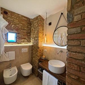 Baño de piedra con 2 lavabos y espejo en Podere Bellavista, en San Gimignano