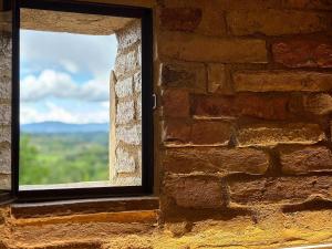 une fenêtre dans un mur en briques avec vue dans l'établissement Podere Bellavista, à San Gimignano