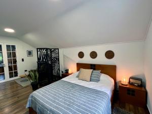 a bedroom with a bed and two lights on the wall at Traditional House in Curral das Freiras