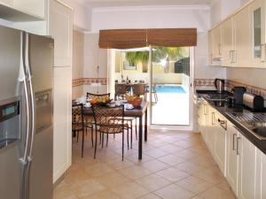聖巴巴拉德尼克斯的住宿－Holiday Home Quinta da Fonte - SBN201 by Interhome，一间带桌椅的厨房和一间用餐室