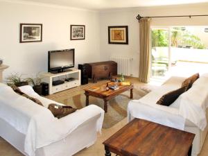 sala de estar con 2 sofás blancos y TV en Holiday Home Quinta da Fonte - SBN201 by Interhome en Santa Bárbara de Nexe
