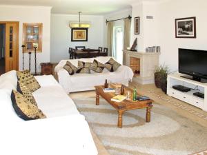 uma sala de estar com dois sofás brancos e uma televisão em Holiday Home Quinta da Fonte - SBN201 by Interhome em Santa Bárbara de Nexe