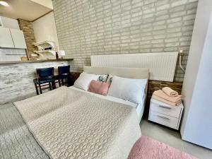 1 dormitorio con 1 cama blanca y cocina en White Rose Guest Rooms, en Burgas