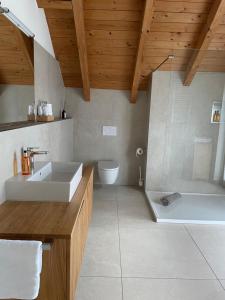een badkamer met een wastafel, een bad en een toilet bij Scherauer Hof in Leinburg