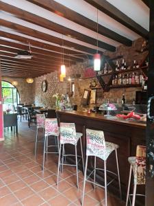 um restaurante com um bar com cadeiras cor-de-rosa e brancas em POSADA LAS MOZAS DEL AGUA DE GABY Y TINO em Ríocorvo