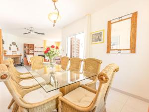 a dining room with a glass table and wicker chairs at Holiday Home Santiago - RDB100 by Interhome in Roda de Bará +34 photos