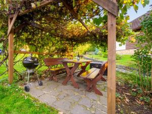 a picnic table and a grill under a pergola at Holiday Home Horní Prysk by Interhome in Liberec