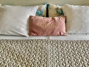 un grupo de almohadas sentadas en una cama en White Rose Guest Rooms, en Burgas