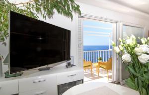 a living room with a large television and a balcony at Kate's Place in Dubrovnik