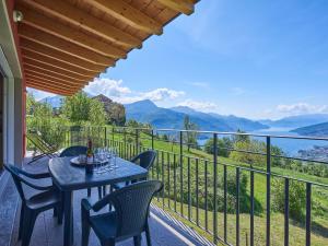 a table and chairs on a balcony with a view of mountains at Holiday Home Cà da Crus - GRV447 by Interhome in Livo