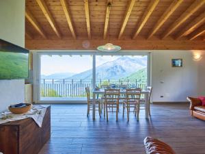 a living room with a table and chairs and a large window at Holiday Home Cà da Crus - GRV447 by Interhome in Livo