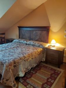 - une chambre avec un grand lit et une tête de lit en bois dans l'établissement POSADA LAS MOZAS DEL AGUA DE GABY Y TINO, à Ríocorvo