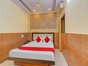 1 dormitorio con 1 cama con almohadas rojas en OYO Flagship 81128 Hotel Preet Palace, en Ranchi