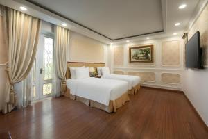 a bedroom with two beds and a flat screen tv at The Light Hotel in Hanoi