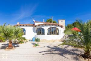 a white house with palm trees in front of it at Villa Nani by Abahana Villas in Calpe