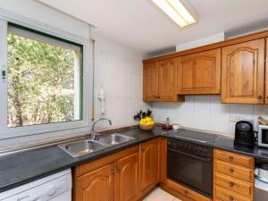 a kitchen with wooden cabinets and a window at Apartment Mediterrani by Interhome in Llança