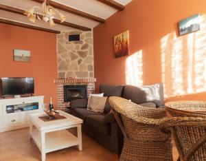 a living room with a couch and a fireplace at Peña Caballera in Cardeñosa
