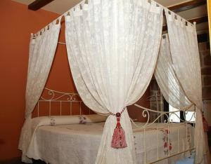 a bedroom with a canopy bed with white curtains at Peña Caballera in Cardeñosa