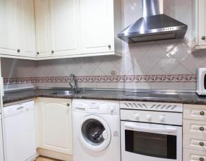 a kitchen with a sink and a stove top oven at Peña Caballera in Cardeñosa