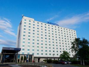 a large white building with a new york hotel at Novotel Kraków City West in Krakow