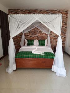 um quarto com uma cama de dossel em Queen's Way Resort em Kisumu